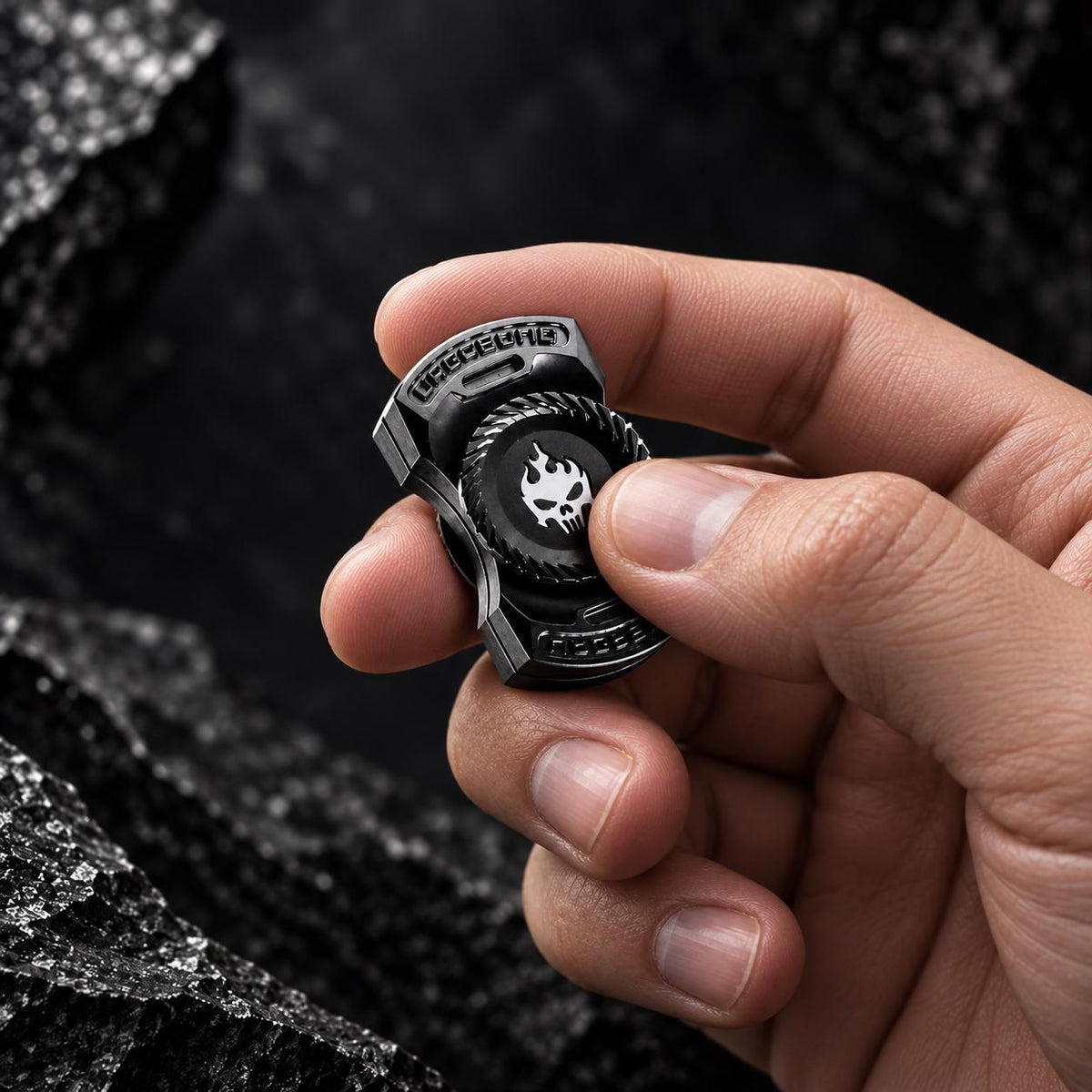 Fidget de poche métallique noir avec motif tête de mort, tenu en main