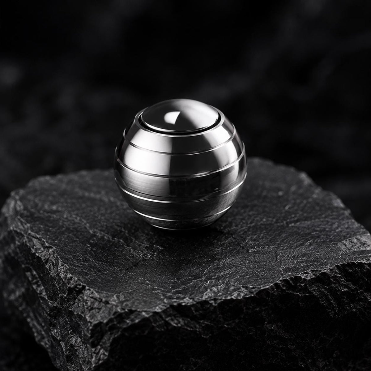 Gyroscope spinner métal : sphérique argenté sur pierre